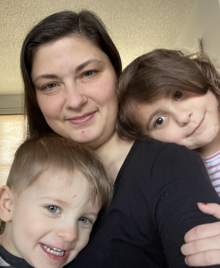 Veronica, the founder of The Networking Mompreneaur, smiles at the camera with her two young children. The Networking Mompreneaur is a women networking group designed to help moms juggle the family and work-life balance.
